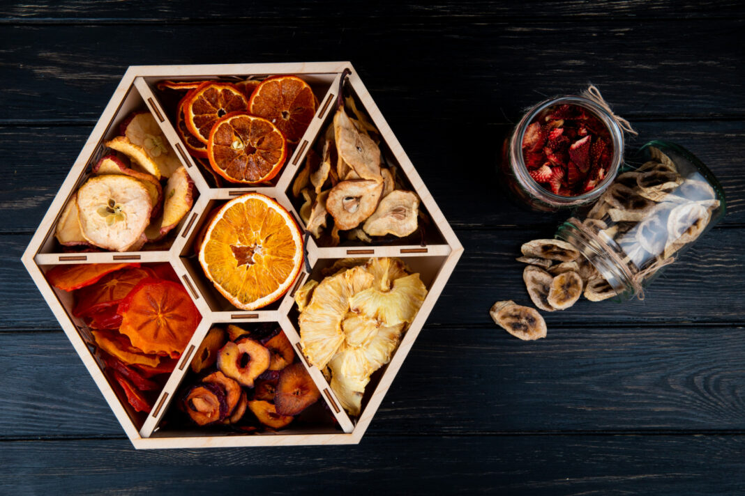 top view set dried fruits wooden box dried banana strawberry chips glass jars black background